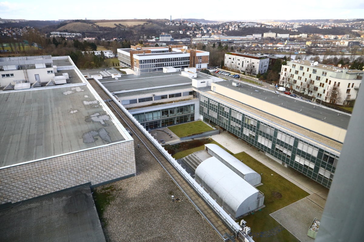 Nejdřív překvapivě míříme nahoru, až pod střechu. Výtah nás vyveze do devátého patra, kde mimochodem sídlí redakce Nových médií ČT. Je odsud výhled na část televizního komplexu na Kavčích horách. V samostatné budově v pozadí sídlí zpravodajství.