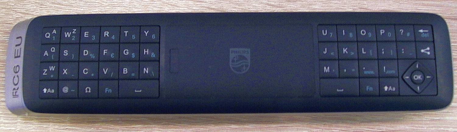 QWERTY strana ovladače je taktéž trochu upravená. Uprostřed mezi oběma částmi klávesnice je víčko skrývající tužkové baterie.