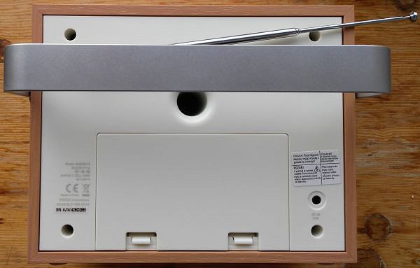 Zadní strana skrývá teleskopickou anténu, připojení napájení, schránku pro klasicky výměnné baterie a bassreflex… Opěrka je v maximální (zadní) poloze.