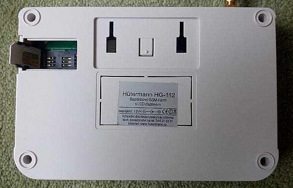 Zadní strana základní jednotky. Vlevo vidíte místo pro mechaniku SIM karty u níž je rovněž posuvný jezdec pro zapnutí a vypnutí ústředny.