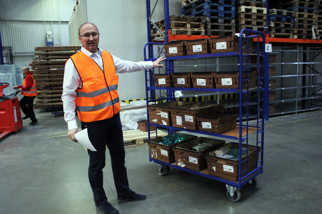 Systém už má v tu chvíli bedýnky přiřazené k jednotlivým dodávkám a trasám rozvážky. Z vozíku si bedýnky přebírají jednotliví příručí. Scannerem zkontrolují, jestli je nákup kompletní.