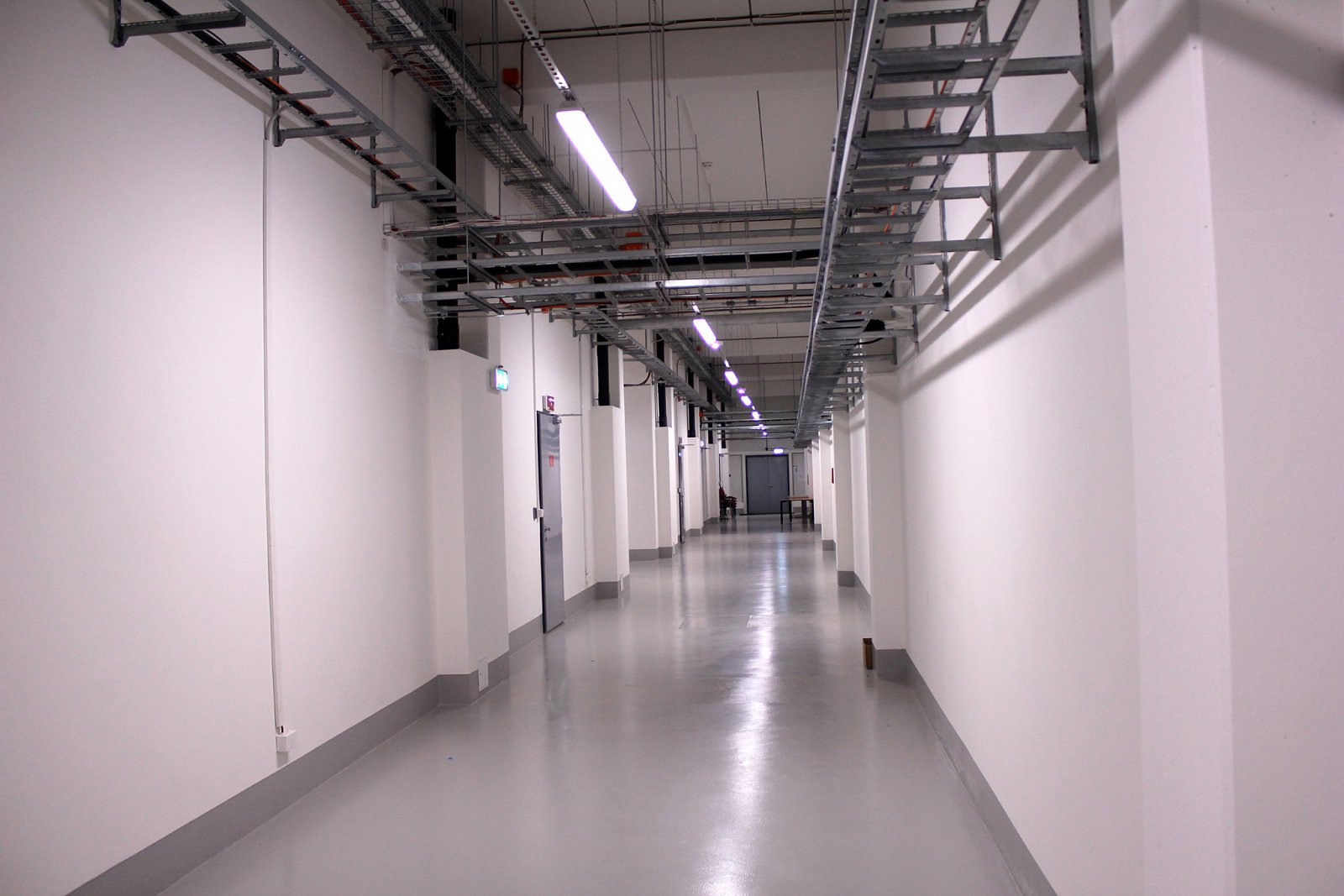 Technologická chodba dělí budovu na dvě poloviny – vpravo se nacházejí datasály a v levé půlce non-IT technologie a podpůrná část. Každá z těchto polovin je pomyslně rozdělena také na půl – každá obsahuje jeden datasál a jeho příslušné podpůrné prostory.