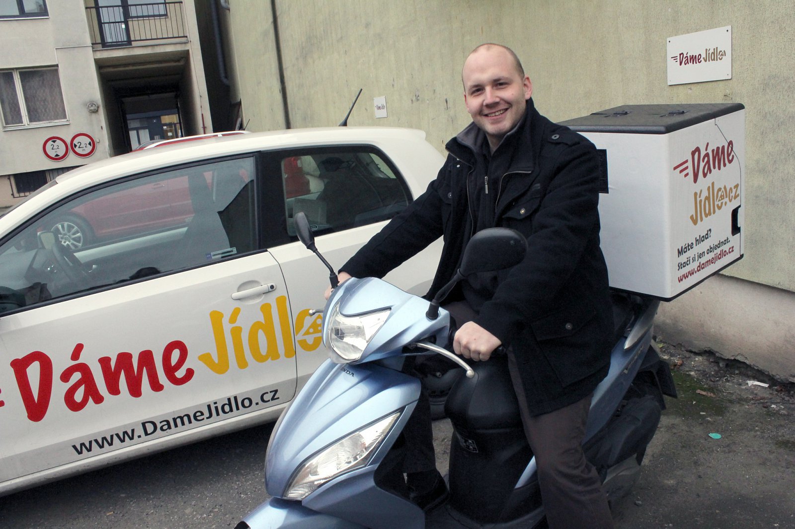Když jsem začínal, taky jsem si vyzkoušel práci kurýra, říká Lukáš Uhl a pózuje na firemním skútru.