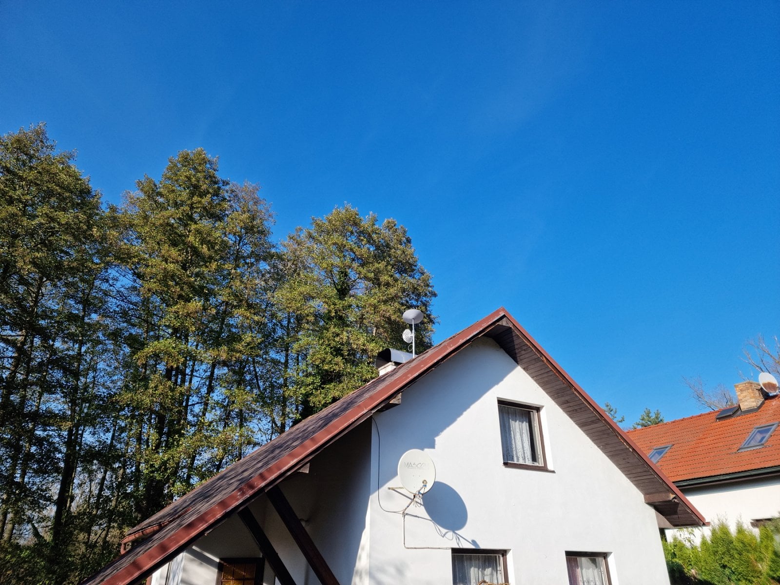 První instalace - LTE a Starlink. V pozadí stromy.