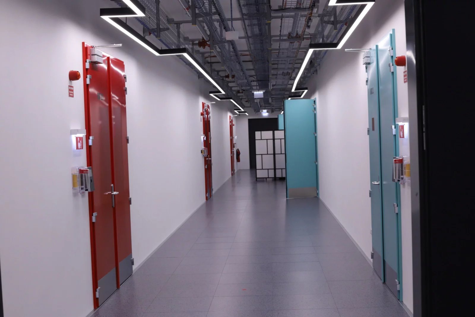 Datacentrum stojí na místě bývalé skládky odpadního materiálu z výkopů metra. První křídlo je postavené na betonové desce položené přímo na zem, druhé stojí na sadě pilotů, které jdou místy do hloubky až 18 metrů. T-Mobile si v datacentru testuje i privátní 5G síť, o té ale podrobněji až později.